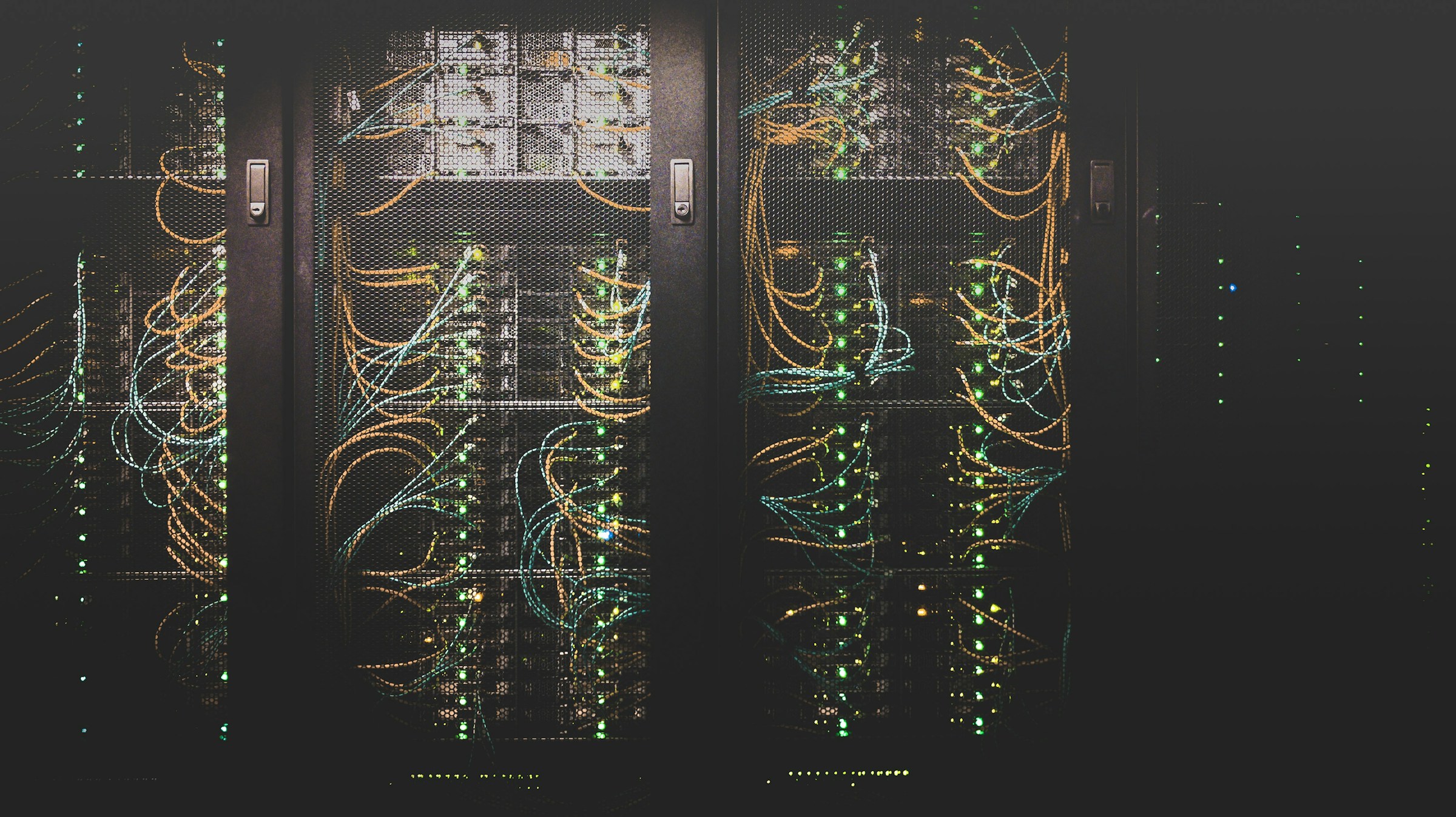Moderní serverovna s racky a modře nasvícenou technologickou infrastrukturou